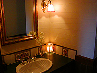 美しい２トーンの真鍮の水栓を持つ洗面台。花のタイルは英国から。